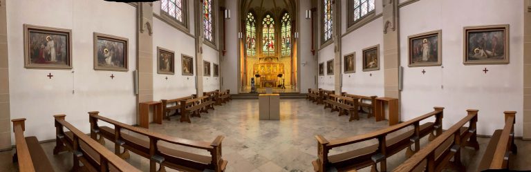 Das Bild zeigt das Innere der Tilbecker Kapelle. Man sieht einige Bänke und blickt auf den Altar.